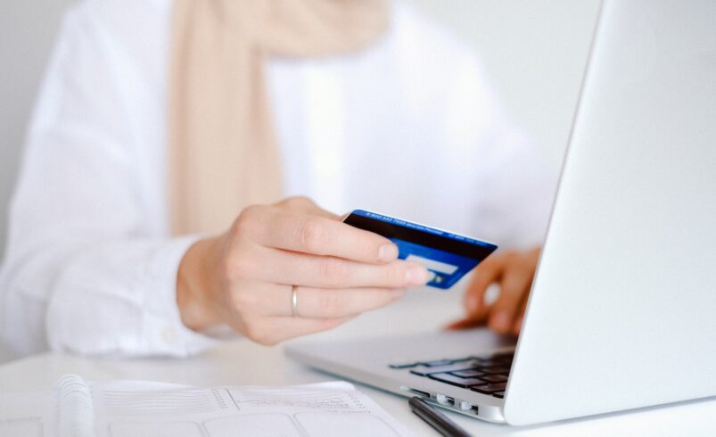 Person in White Long Sleeve Shirt Holding Credit Card
