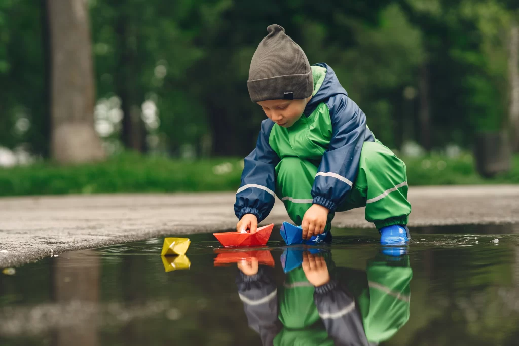 Dítě si hraje po dešti