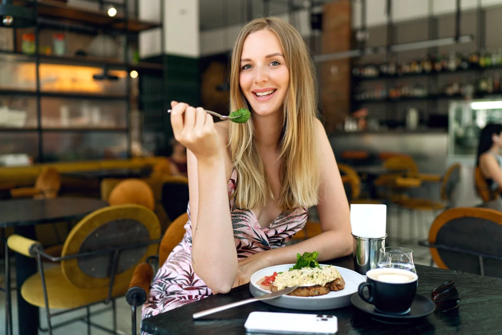 Žena si pochutnává na obědě v restauraci