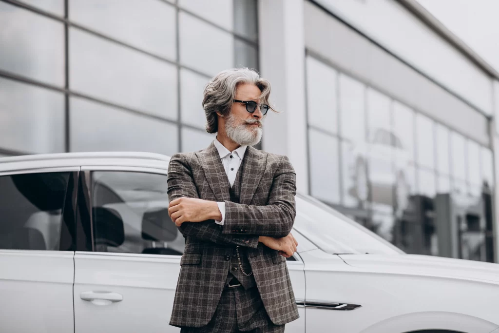 Bohatý muž stojí u svého vozu