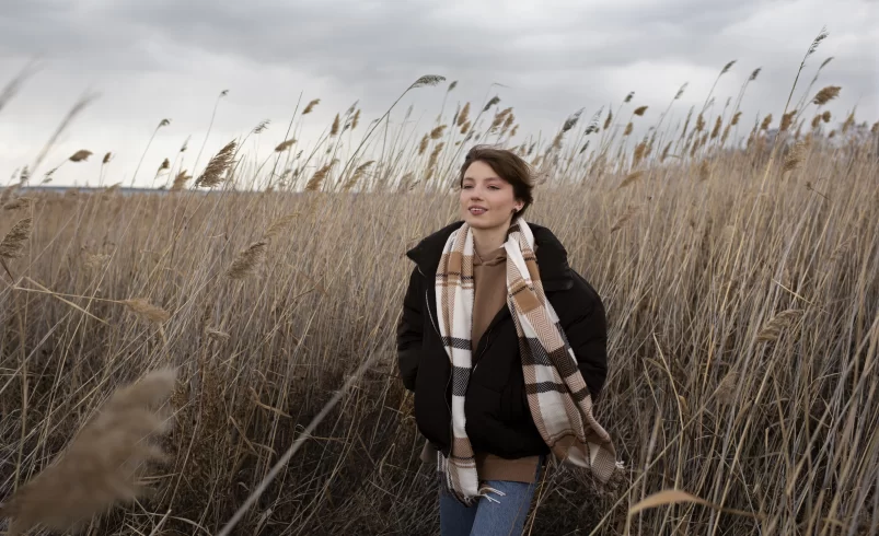 Žena stojí venku v nepříznivém počasí
