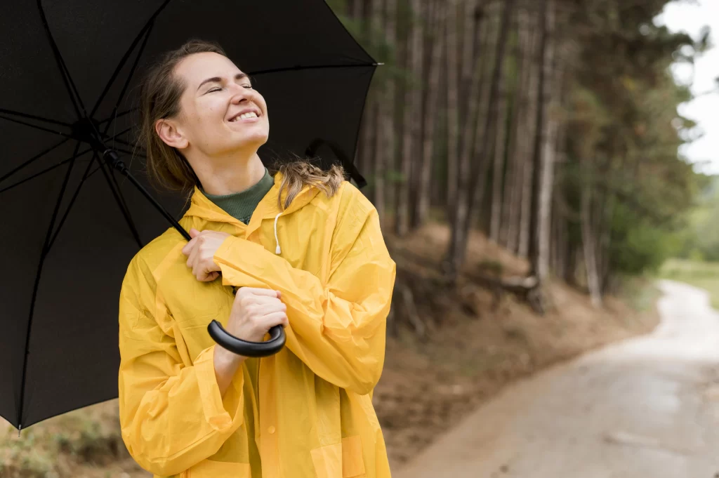 Žena s deštníkem se usmívá, i když venku prší