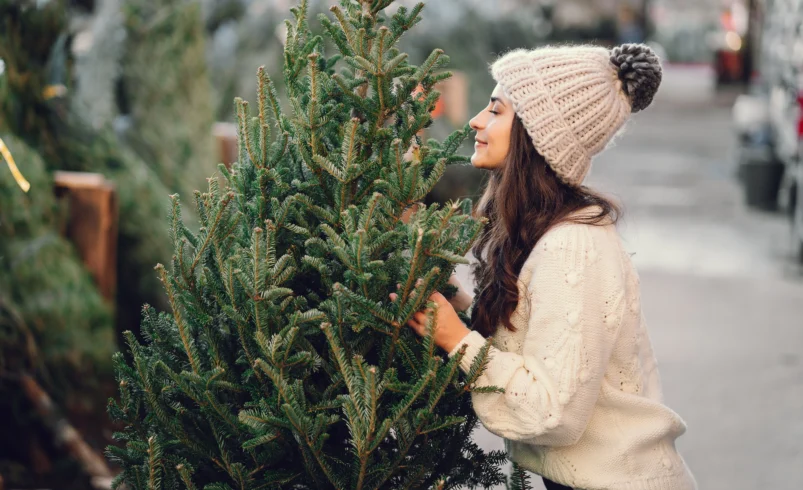 Žena čichá dokonalou vůni vánočního stromku