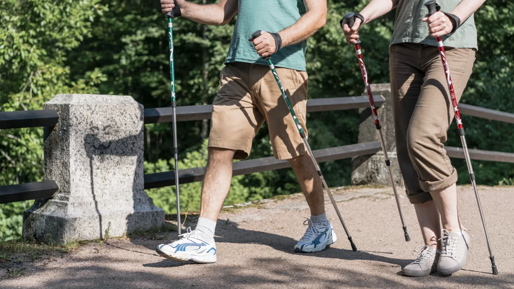 Muž a žena jsou venku a užívají si Nordic walking