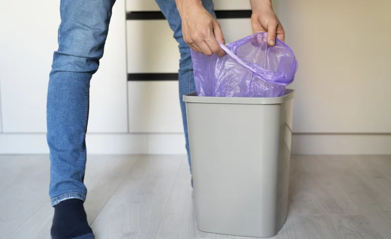 Člověk vyměňuje sáček v odpadkovém koši
