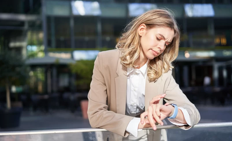 Žena se dívá na hodinky a zjišťuje, že je v časovém skluzu