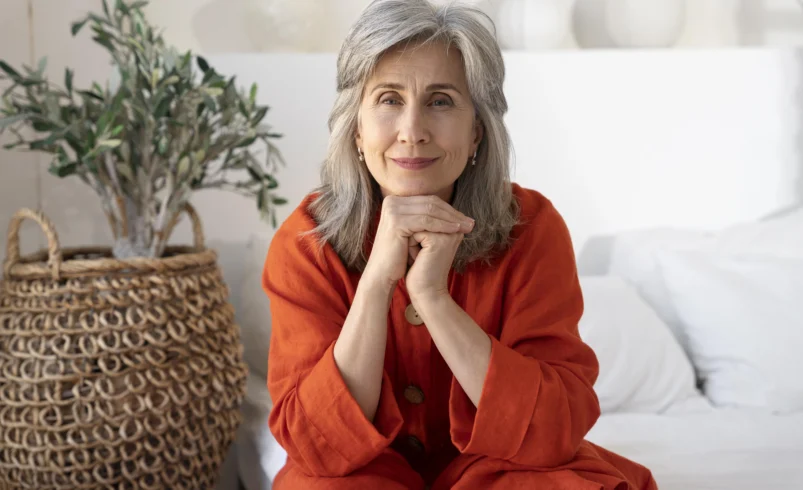 Starší žena sedí a usmívá se