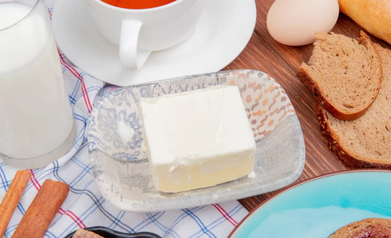 Máslo leží na stole s ostatními surovinami