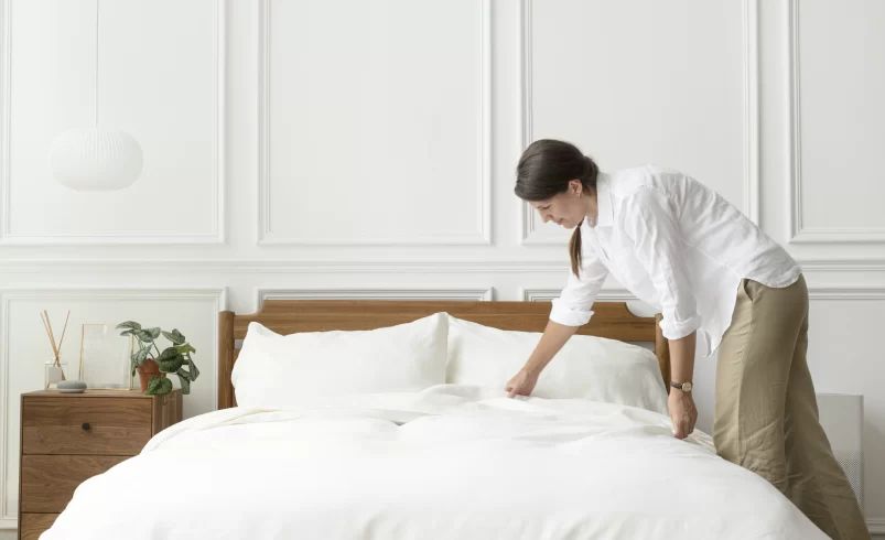 Žena uklízí postel