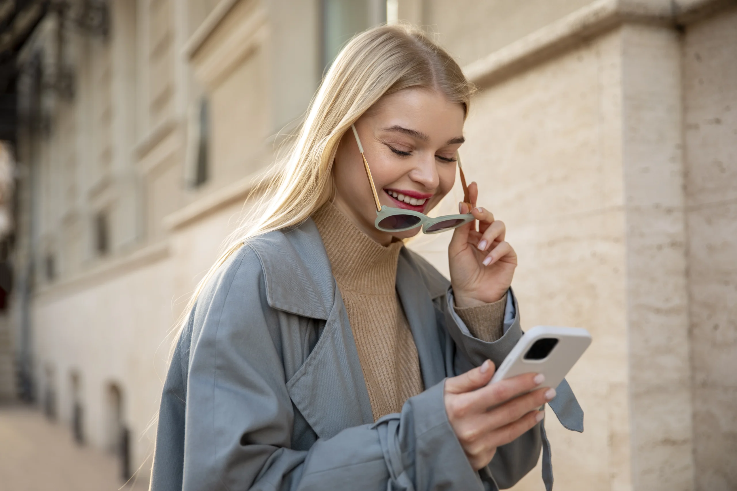 Žena se usmívá do svého mobilního telefonu
