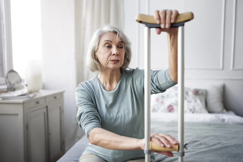 Starší žena sedí ve svém bytě